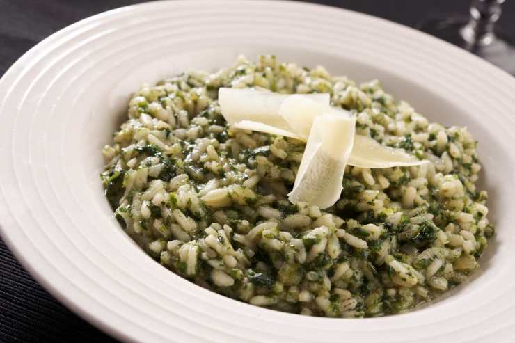 piatto di risotto con gli spinaci e scaglie di parmigiano
