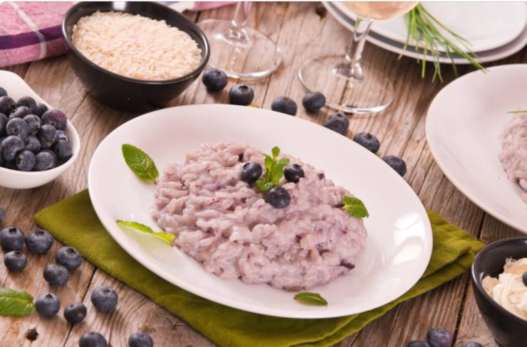 risotto ai mirtilli con sopra mirtilli freschi e foglie di menta