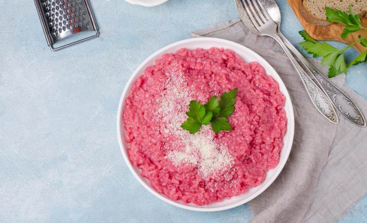 Risotto rosa nel piatto con foglie di menta