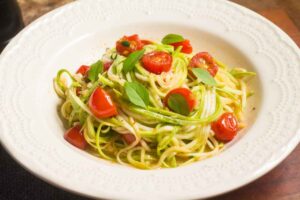 Piatto di spaghetti di zucchine con pomodorini