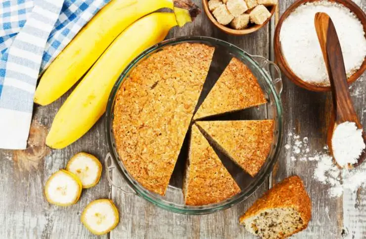 torta in un contenitore di vetro con accanto due banane e della farina