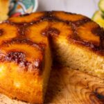 torta all'ananas senza una fetta sopra ad un tagliere di legno