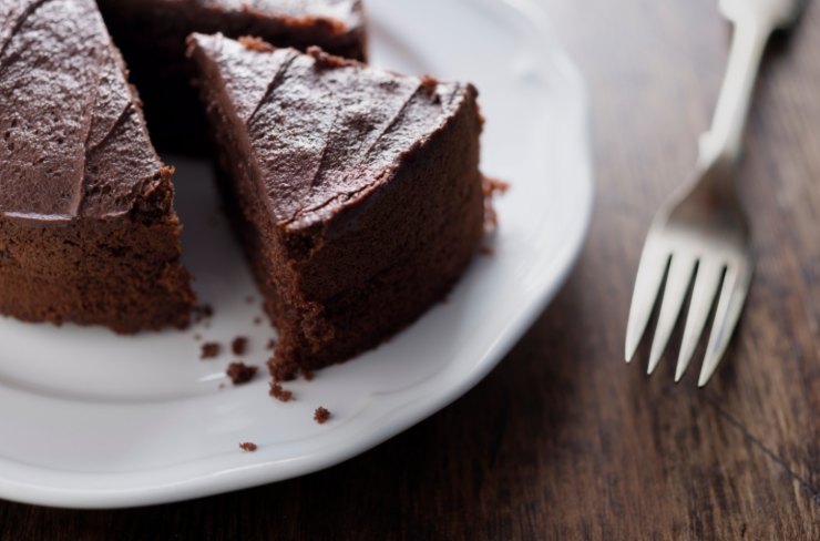 torta al cioccolato sopra ad un piatto bianco con accanto una forchetta