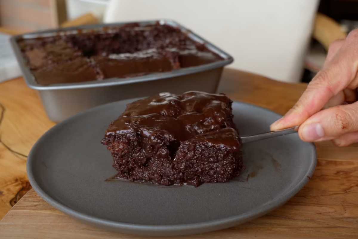 una torta al cioccolato su un piatto con una forchetta a tagliarla