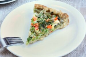 fetta di torta salata su un piatto con accanto una forchetta