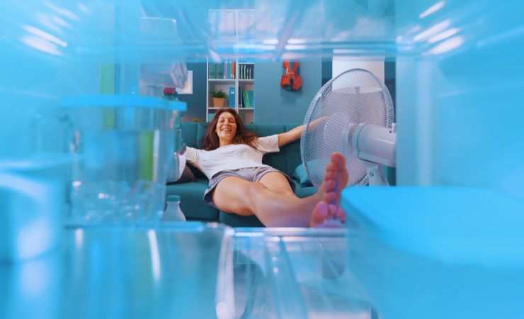 ragazza davanti al congelatore con il ventilatore