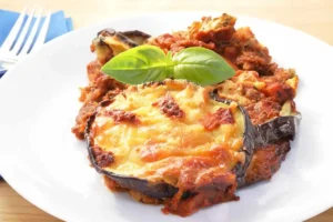 Porzione di pasticcio di melanzane con basilico