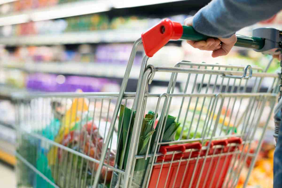 Persona che spinge carrello in un supermercato