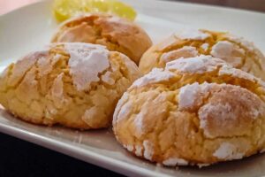 Biscotti cin limone accanto e zucchero a velo
