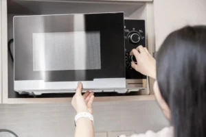 Donna che accendo forno a microonde