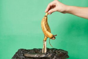 donna che getta via una buccia di banana