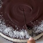 cheesecake virale cocco e cioccolato viene tagliata