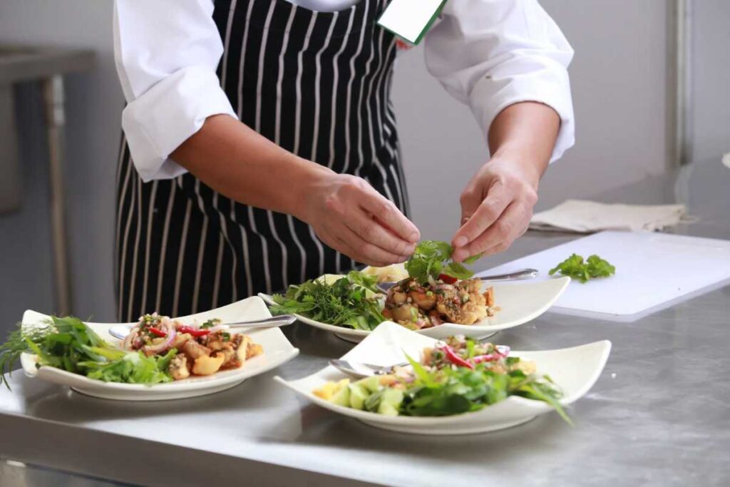 Chef che impiatta pietanze a base di insalata