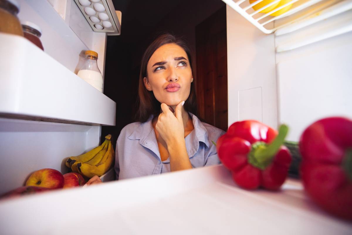 donna che guarda nel frigo