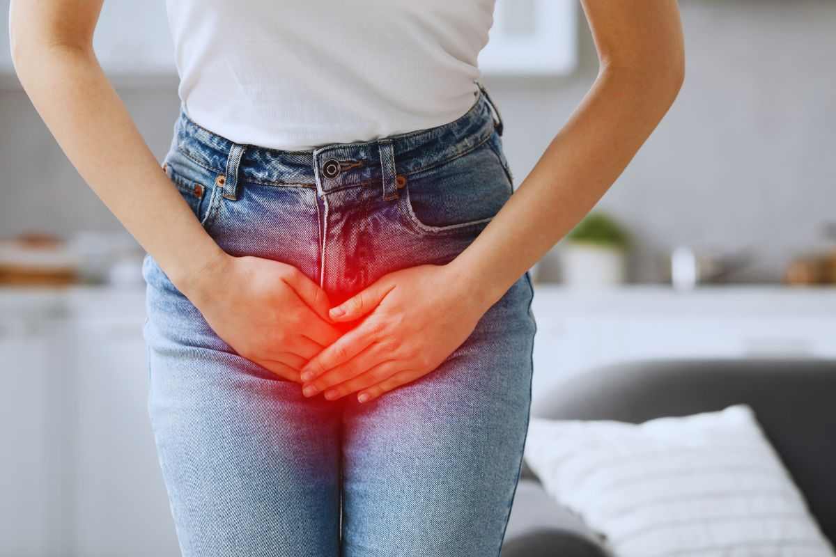 ragazza si tiene la zona pelvica
