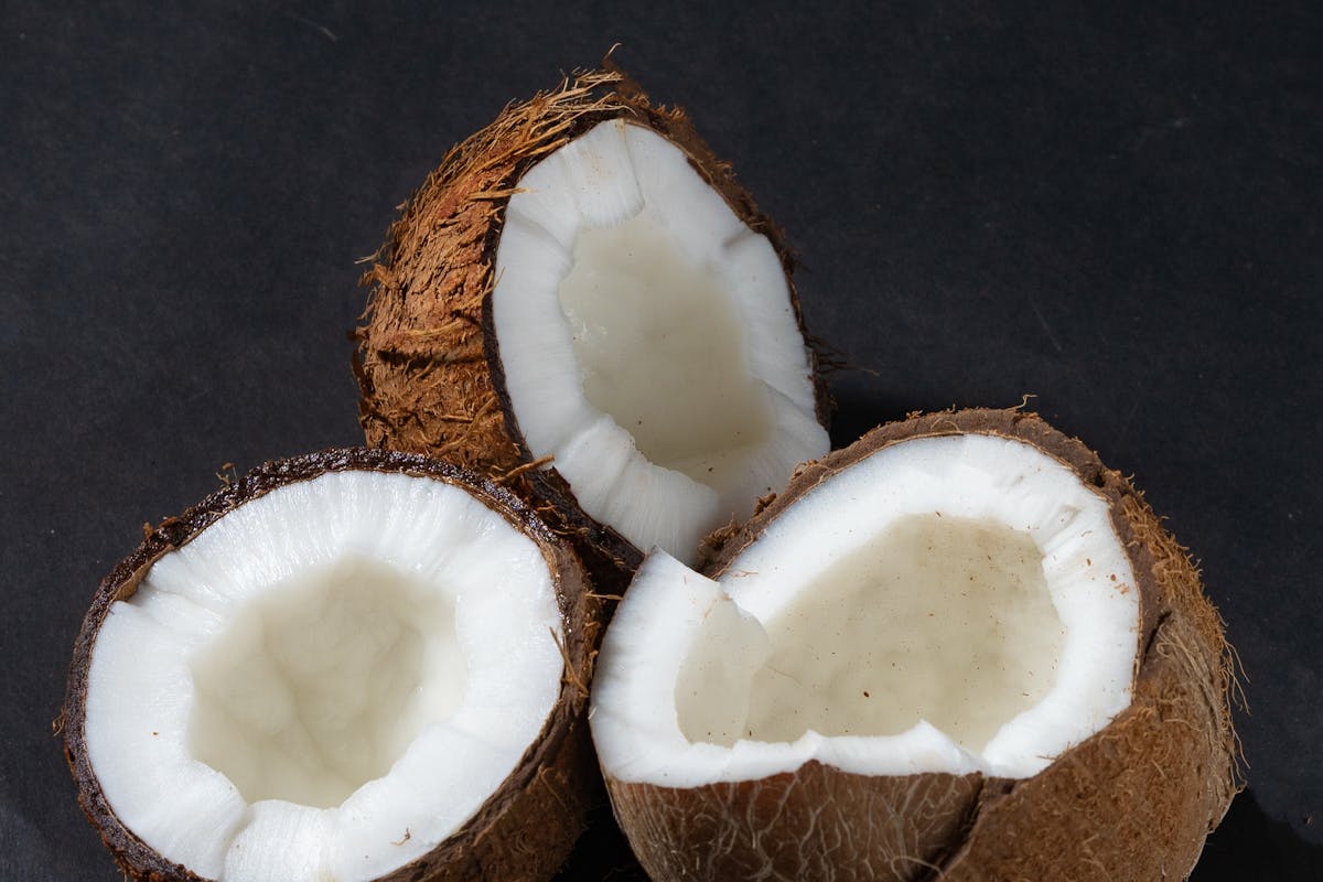 noci di cocco aperte su sfondo nero