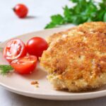 cotolette in un piatto con accanto dei pomodorini