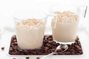 due bicchieri di mousse al caffè e chicchi di caffè