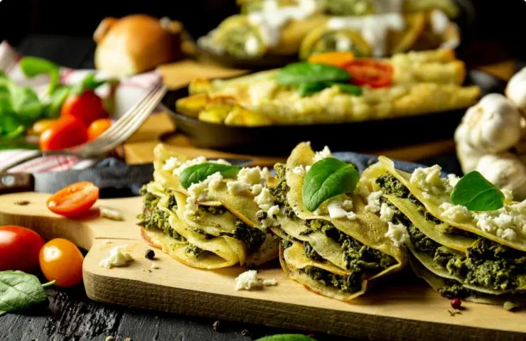 crepes di verdure con sopra del formaggio e delle foglie di basilico