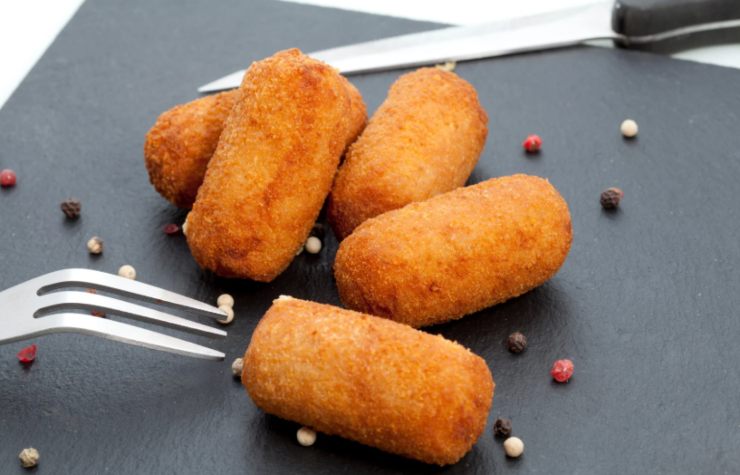 crocchette sopra ad un piatto con accanto forchetta e coltello