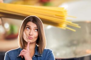 donna pensierosa e spaghetti in mano