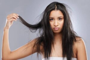 ragazza triste che si tiene una ciocca di capelli