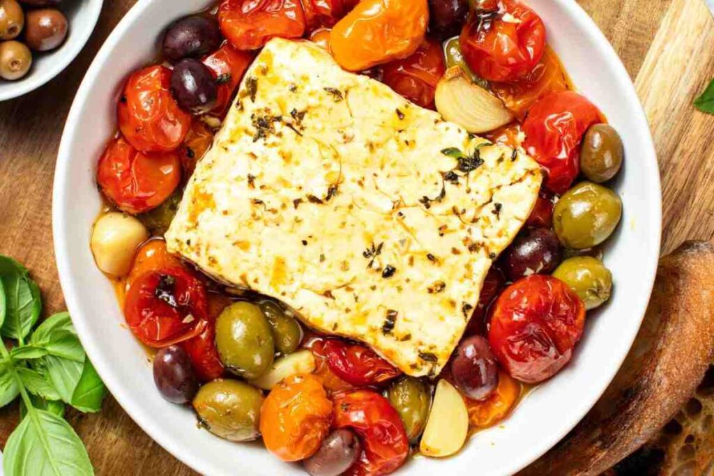 feta al forno in una terrina con pomodorini e olive