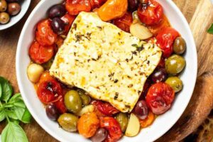 feta al forno in una terrina con pomodorini e olive