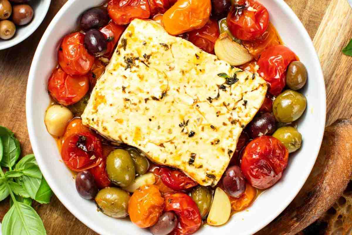 feta al forno in una terrina con pomodorini e olive