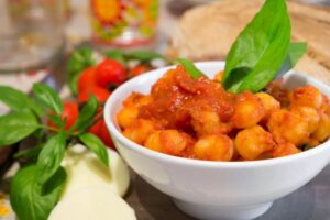 gnocchi al pomodoro con sopra due foglioline di basilico