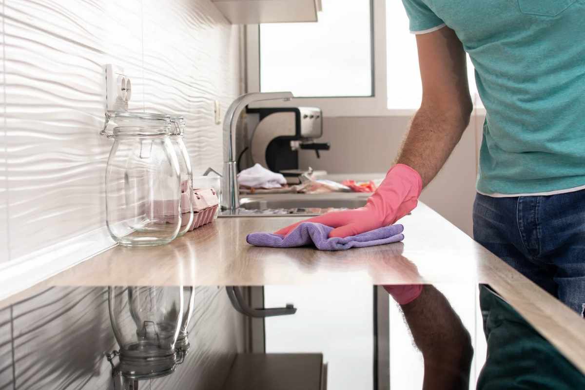 mano che pulisce pianale della cucina