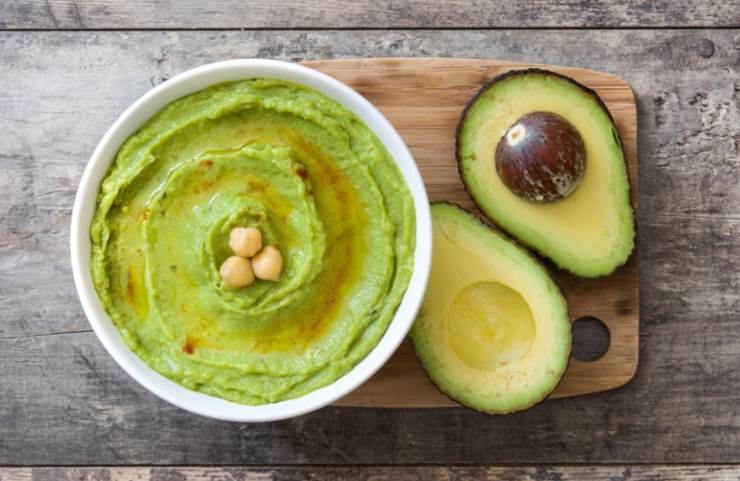 hummus di avocado con accanto un avocado tagliato a metà