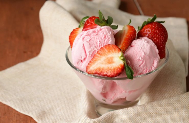 coppa di gelato alla fragola con sopra delle fragole