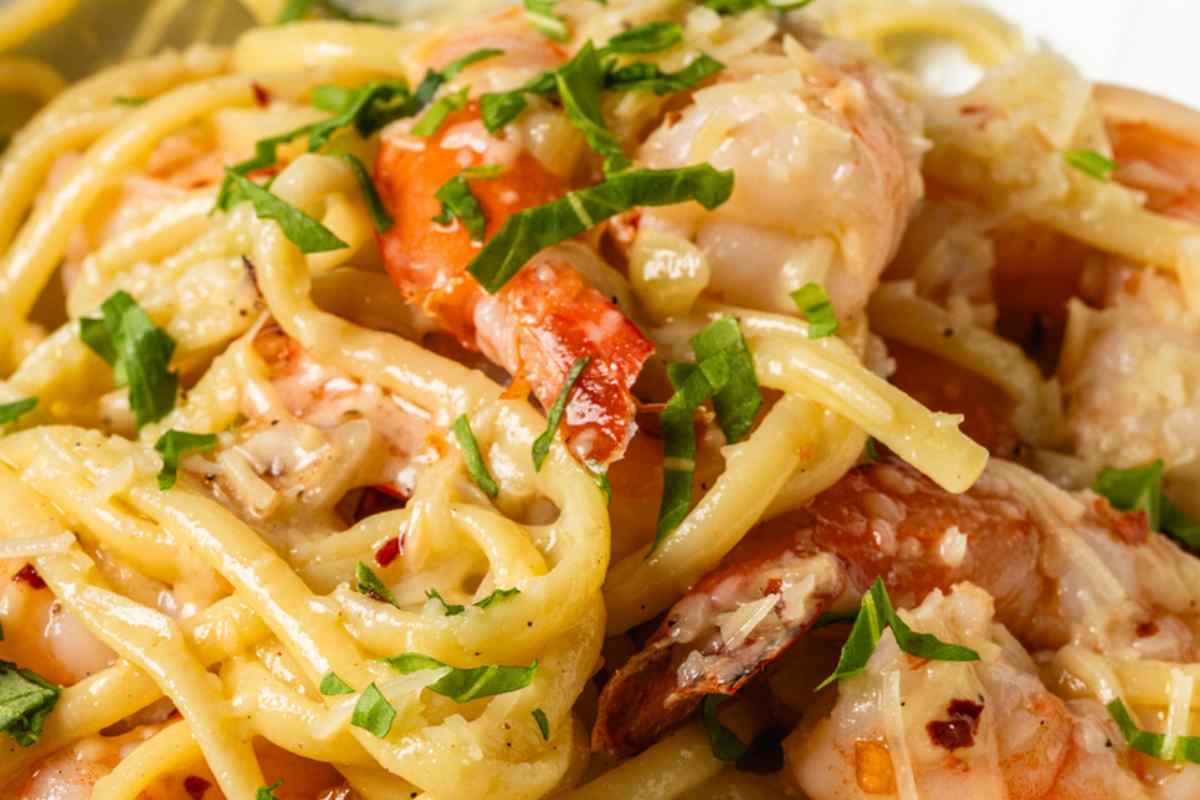 Piatto di linguine con pomodori, gamberi ed erbe aromatiche