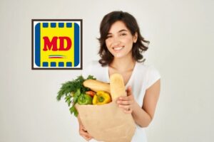 donna che sorride con in mano un sacchetto pieno di pane e ortaggi e logo md