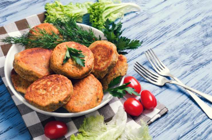 medaglioni vegetali dentro ad un piatto con accanto delle erbe