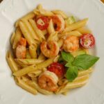 piatto di penne con gamberi e pomodori