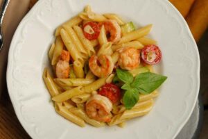 piatto di penne con gamberi e pomodori
