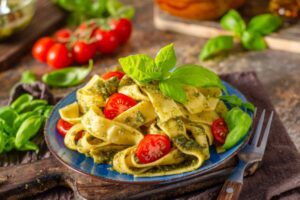 pappardelle con il pesto pomodorini e foglie di basilico