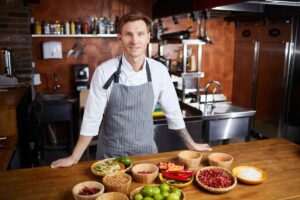 uomo in cucina con dei prodotti alimentari sul tavolo