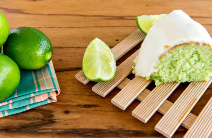 fetta di plumcake menta e lime ricoperta da glassa bianca circondata da lime