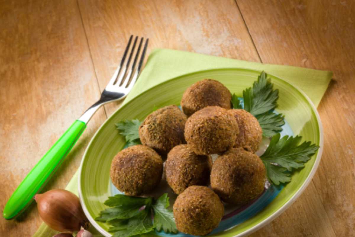 polpette di verdure in un piatto con accanto una forchetta
