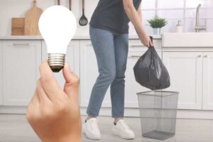 ragazza getta la spazzatura e una mano con una lampadina