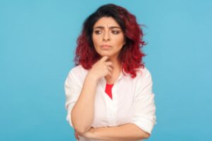 donna con espressione dubbiosa con un dito sotto al mento