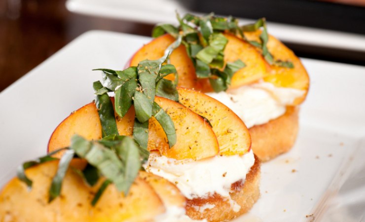 Piatto di bruschette con stracchino e pesche