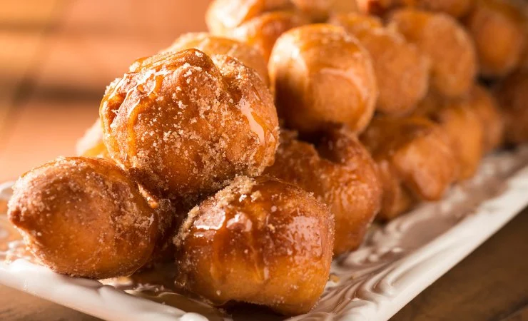 Due strati di frittelle con zucchero su un vassoio