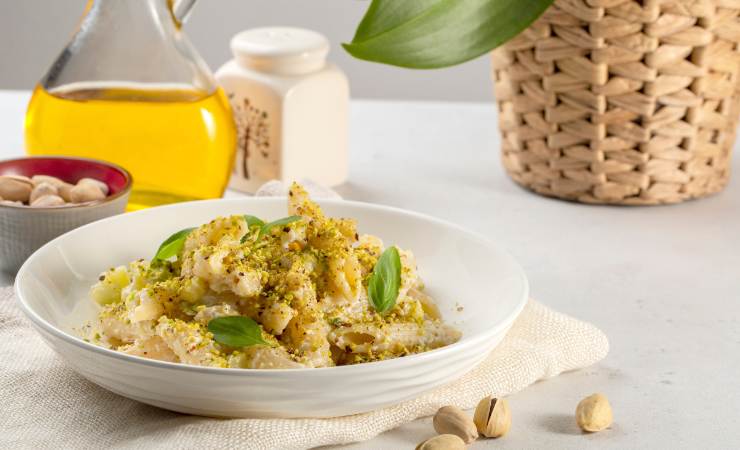 piatto di pasta con pistacchi sul tavolo