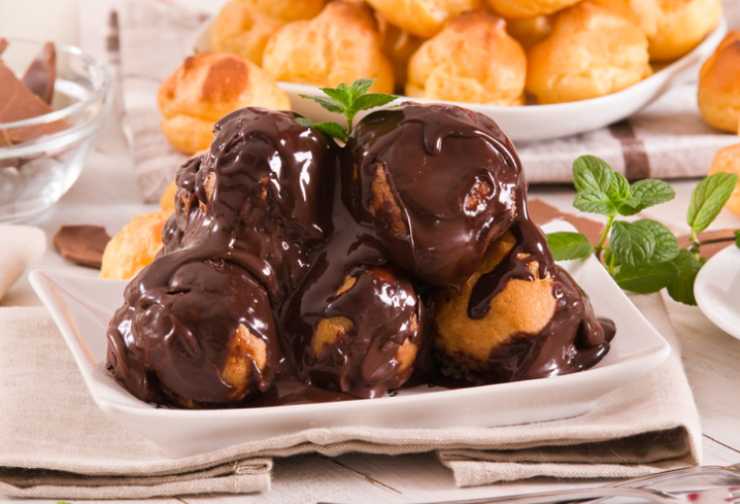 porzione di profiteroles con crema al cioccolato