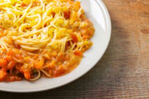 Piatto di spaghetti con sugo e pomodori a pezzetti