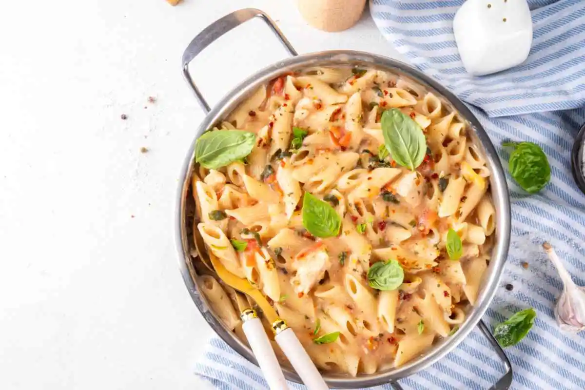 Pentola con pennette, basilico, pomodorini e tonno